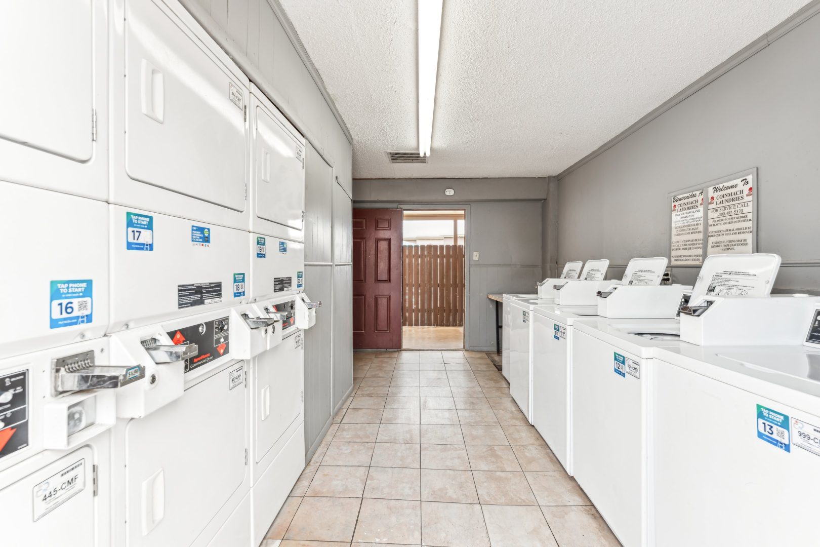 a laundry room with washers and dryers at The Alamo Village Apartments