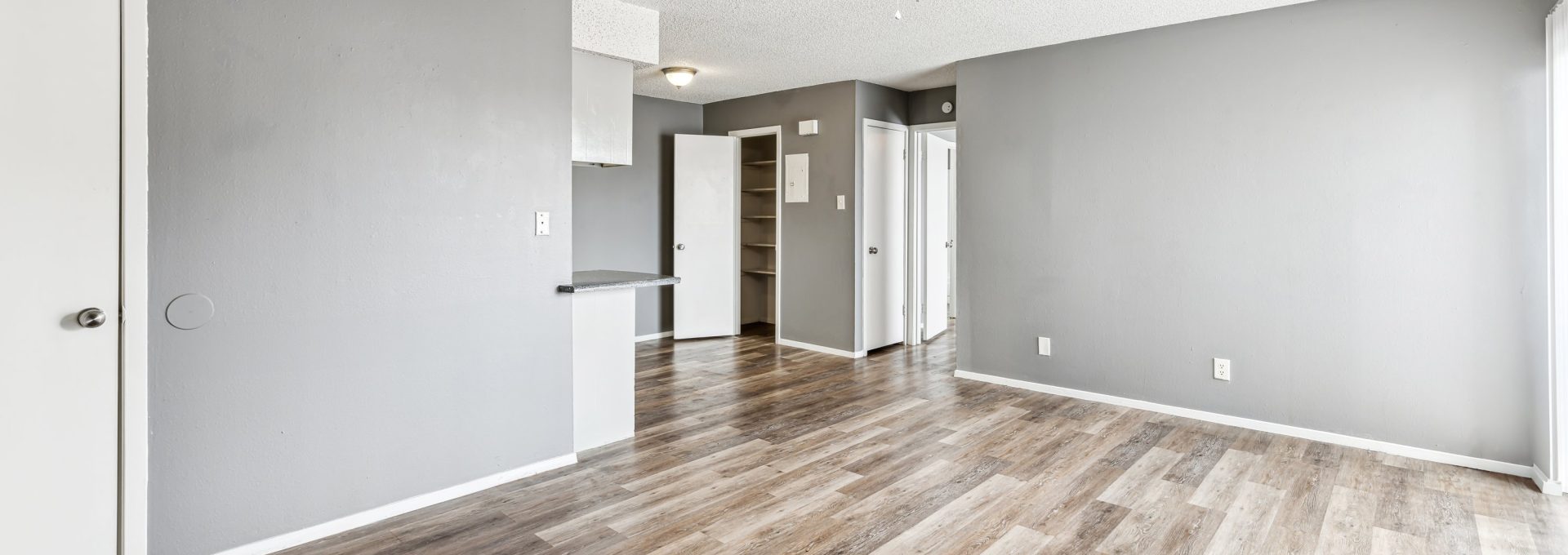 empty room with hardwood floors and ceiling fan at The Alamo Village Apartments