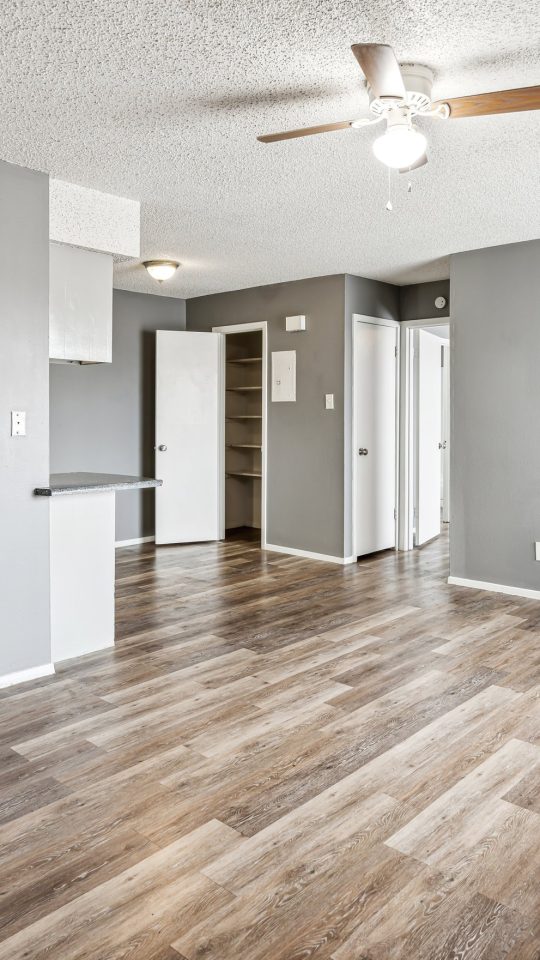 empty room with hardwood floors and ceiling fan at The Alamo Village Apartments